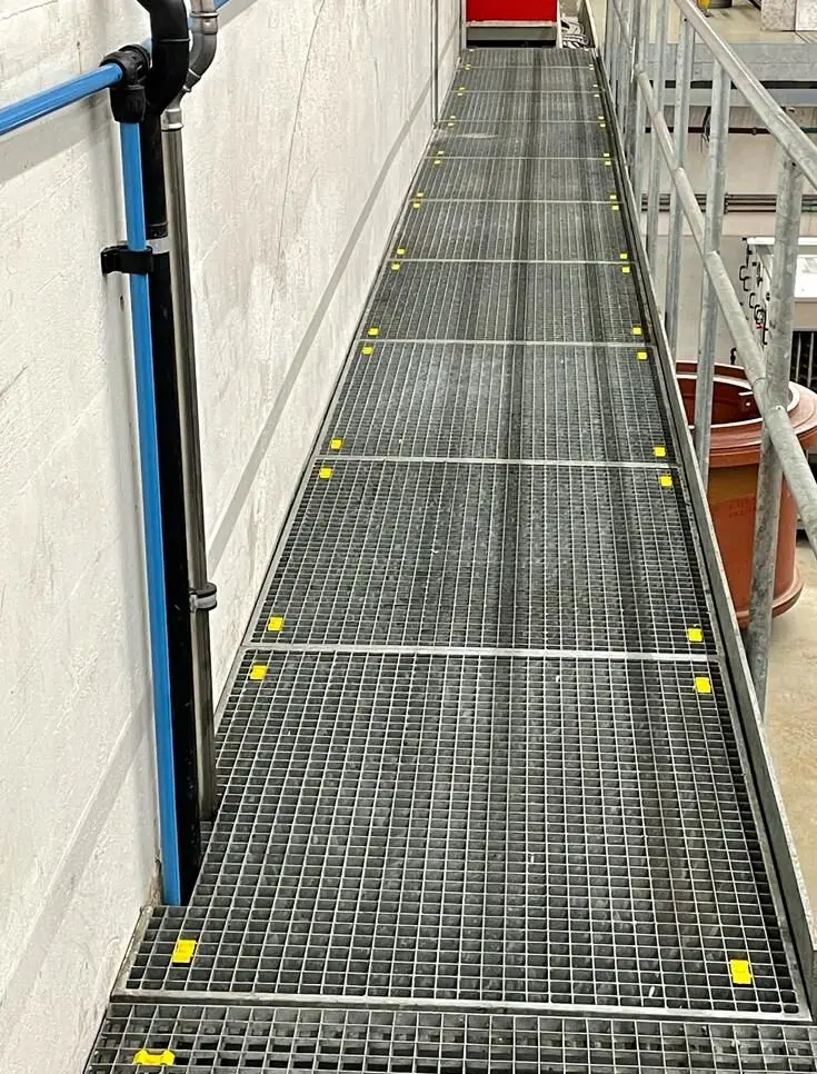 Passerelle en grilles caillebotis marquées en jaune