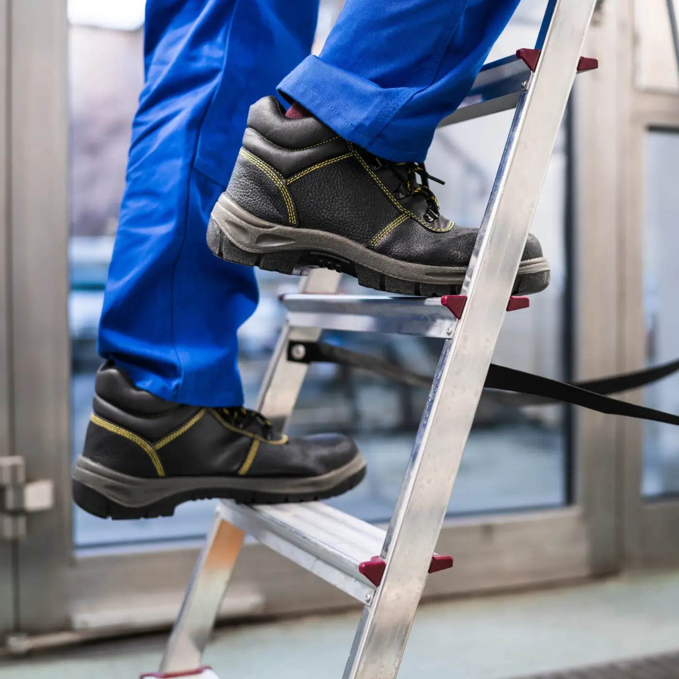Ouvrier en chaussures de sécurité montant une échelle
